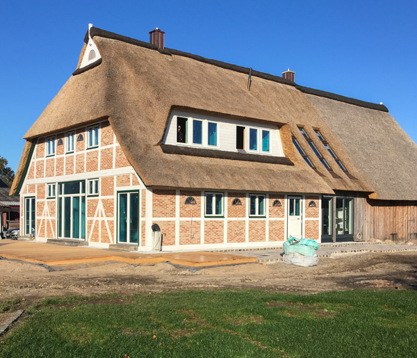 Vierländer Bauernhaus nach der Sanierung: Fachwerk mit Backstein und neuem Reetdach